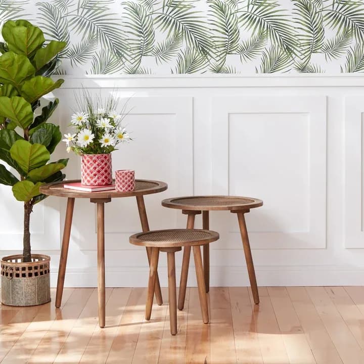 Pier 1 rattan-top nesting side tables beside a potted plant